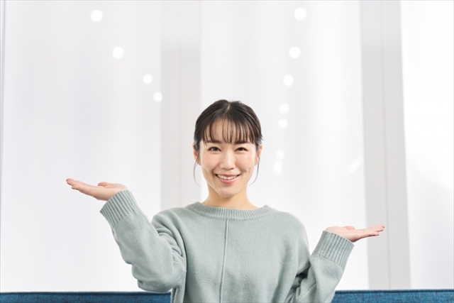 若い女性が両手の手のひらを上に向けて天秤のようにしている