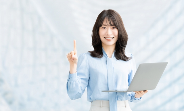 若い女性がノートパソコンを片手に説明している