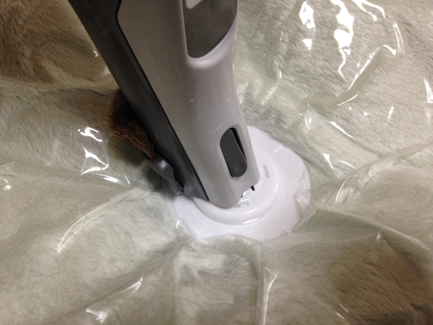 寝具を圧縮袋と掃除機で圧縮している