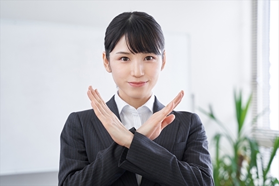 胸の前で両手でクロスして✕印を表現している女性